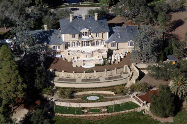 Front view of Oprah Winfrey's $50 million house on a hill near the Californian coast, with party materials stacked in the front garden.