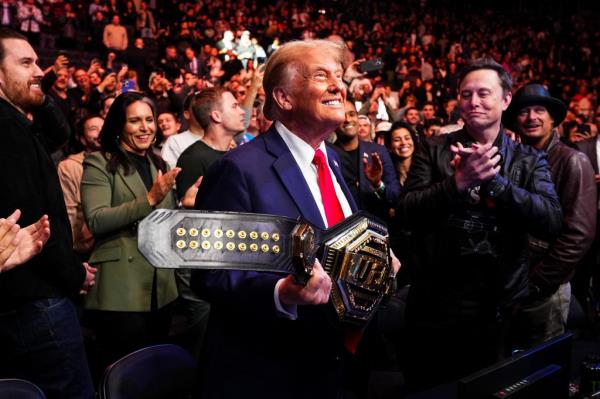 Trump holds the UFC heavyweight champio<em></em>nship belt after Jon Jo<em></em>nes defeated Stipe Miocic.